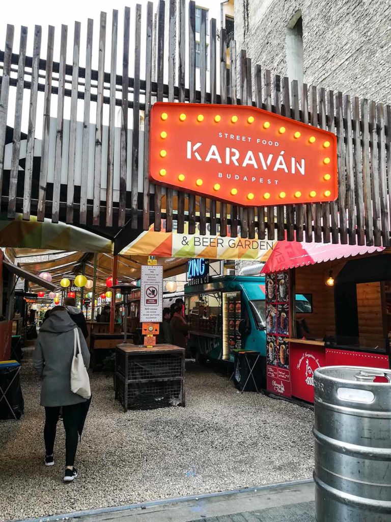 Street food place in Budapest. You can see stalls in the back and a large sign in the front.