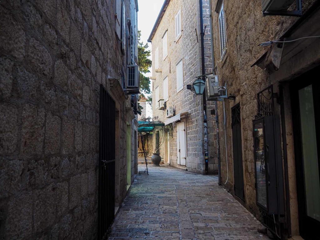 House walls on the left and right side, in the middle a street with cubblestones.